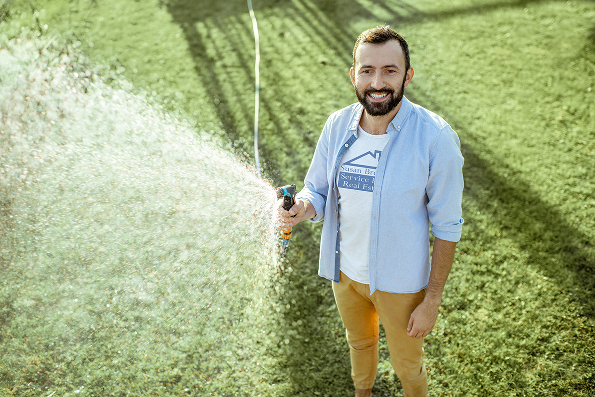 Man watering green lawn