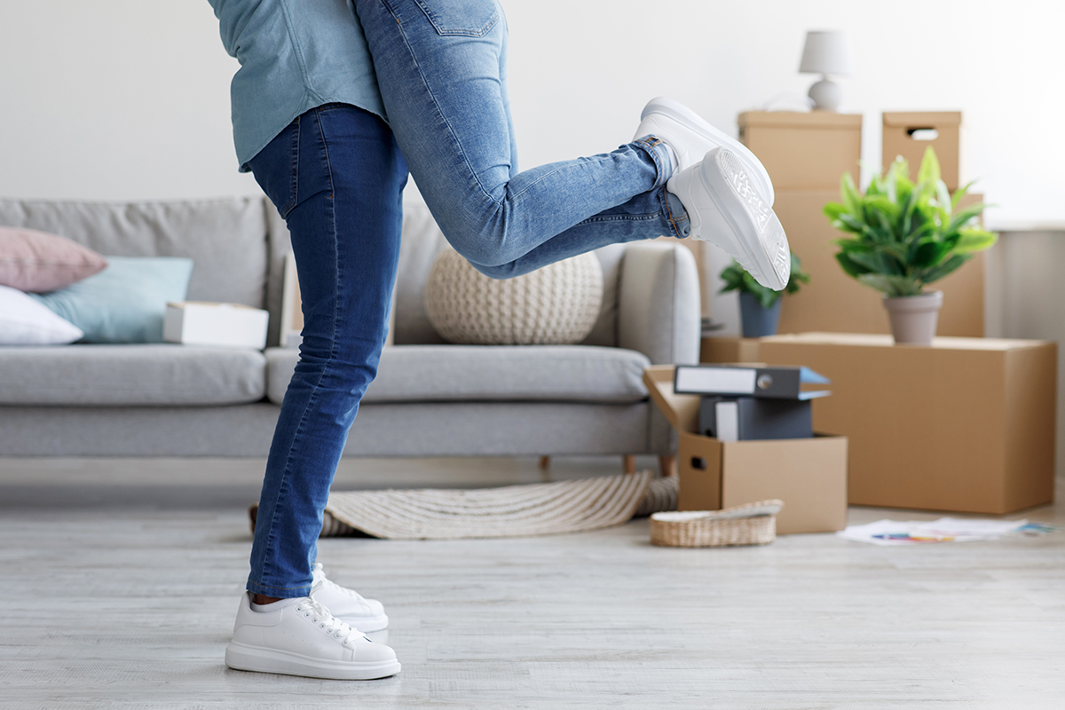 Happy young african american man hugs and lifts lady in apartment, celebrating buying new home