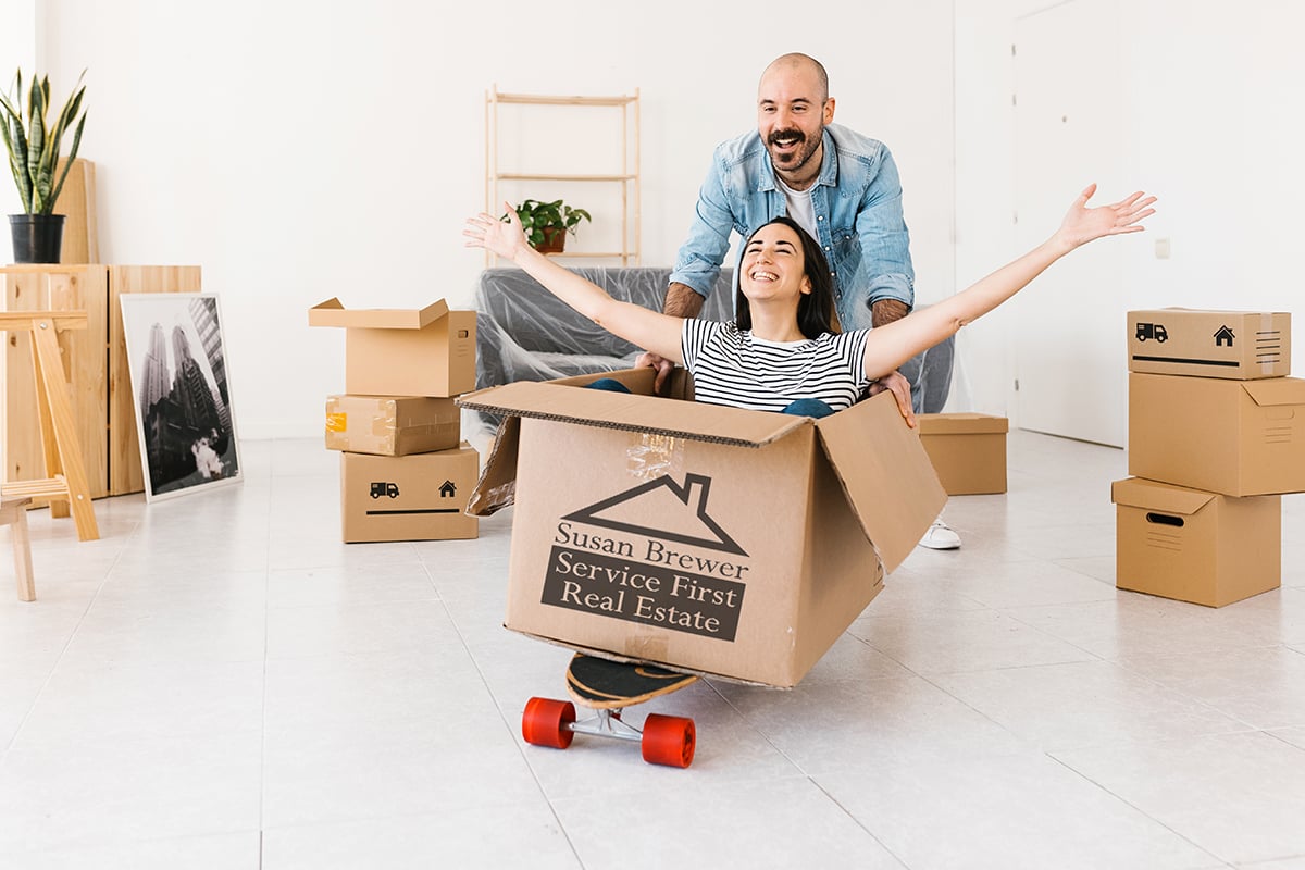 Happy couple having fun while unpacking on moving day in new apa