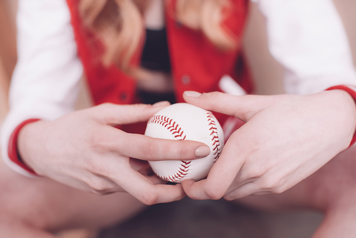 Close up of hipster woman holding baseball ball in hands