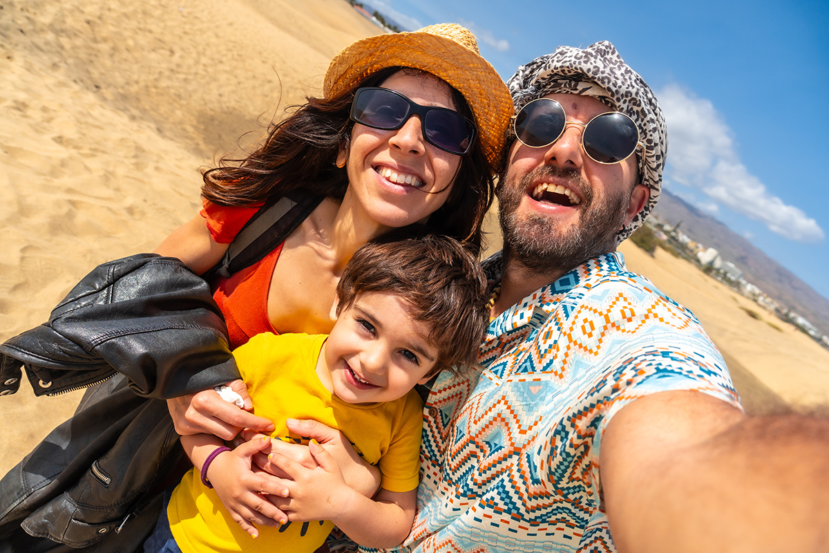 A happy family on summer holidays in the dunes of Maspalomas, Gran Canaria, Canary Islands