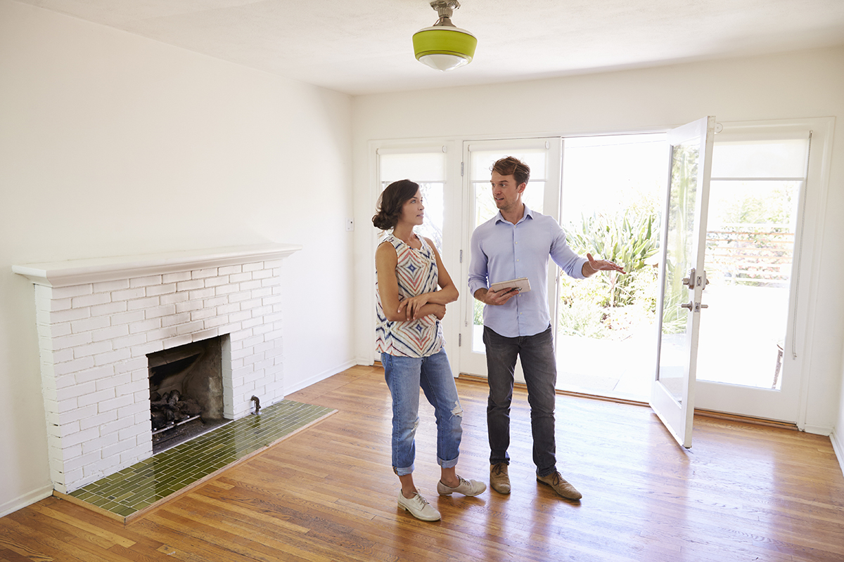Male Realtor Showing Female Client Around House