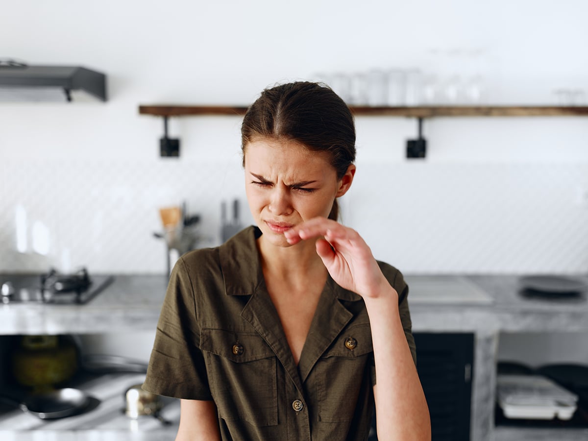 Portrait of a sad tired woman with a sore head in the kitchen, domestic problems, unstable emotional state, onion tears