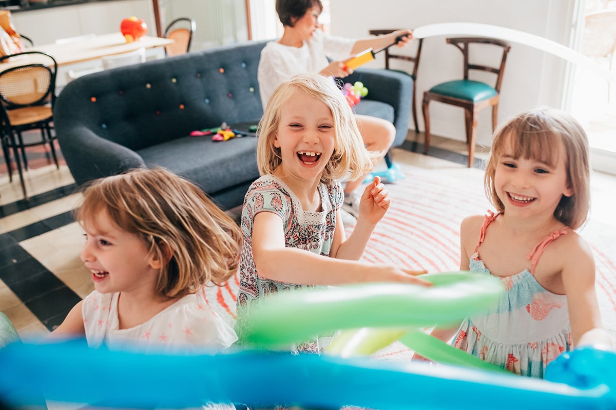 Three female children indoors at home playing