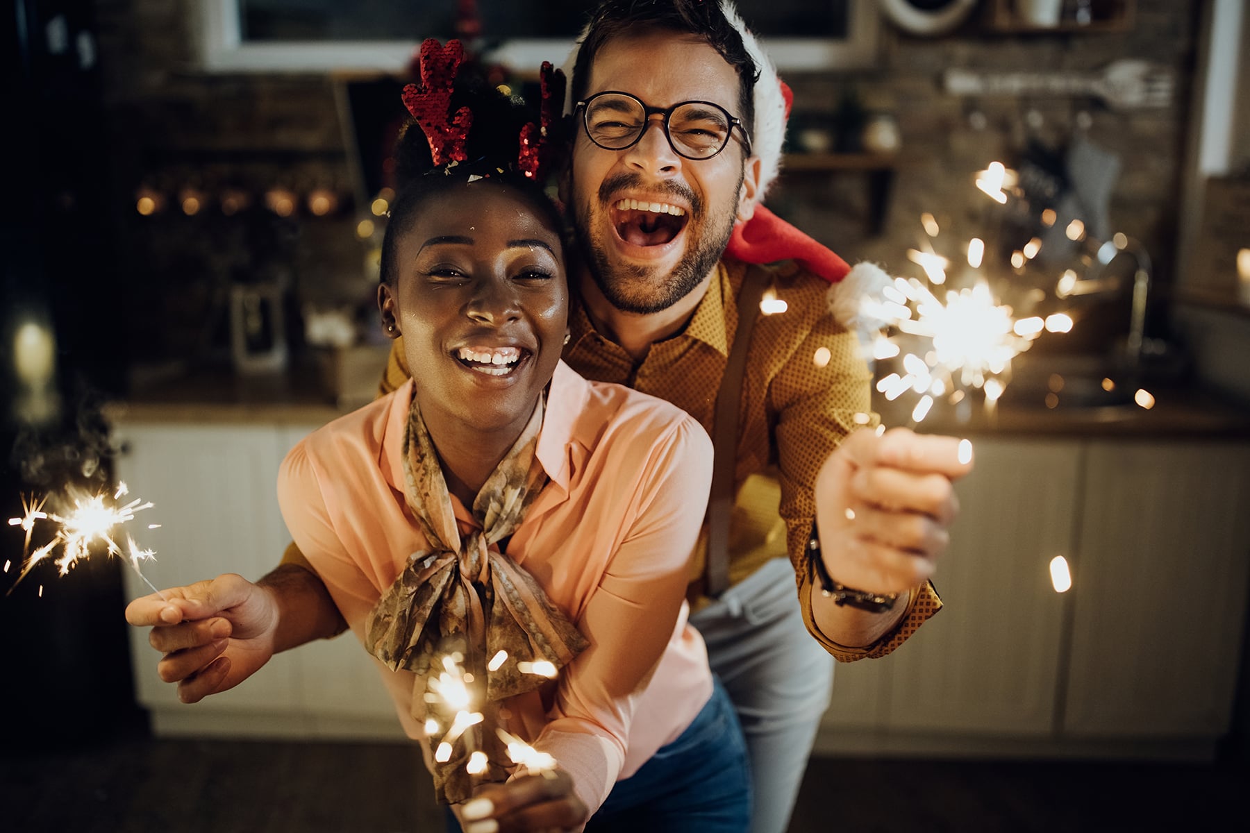 Festive couple having fun while celebrating New year at home.
