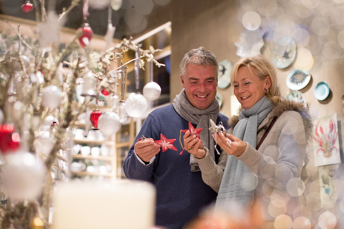 Mature couple choosing star decorations in gift shop, Majorca, Spain