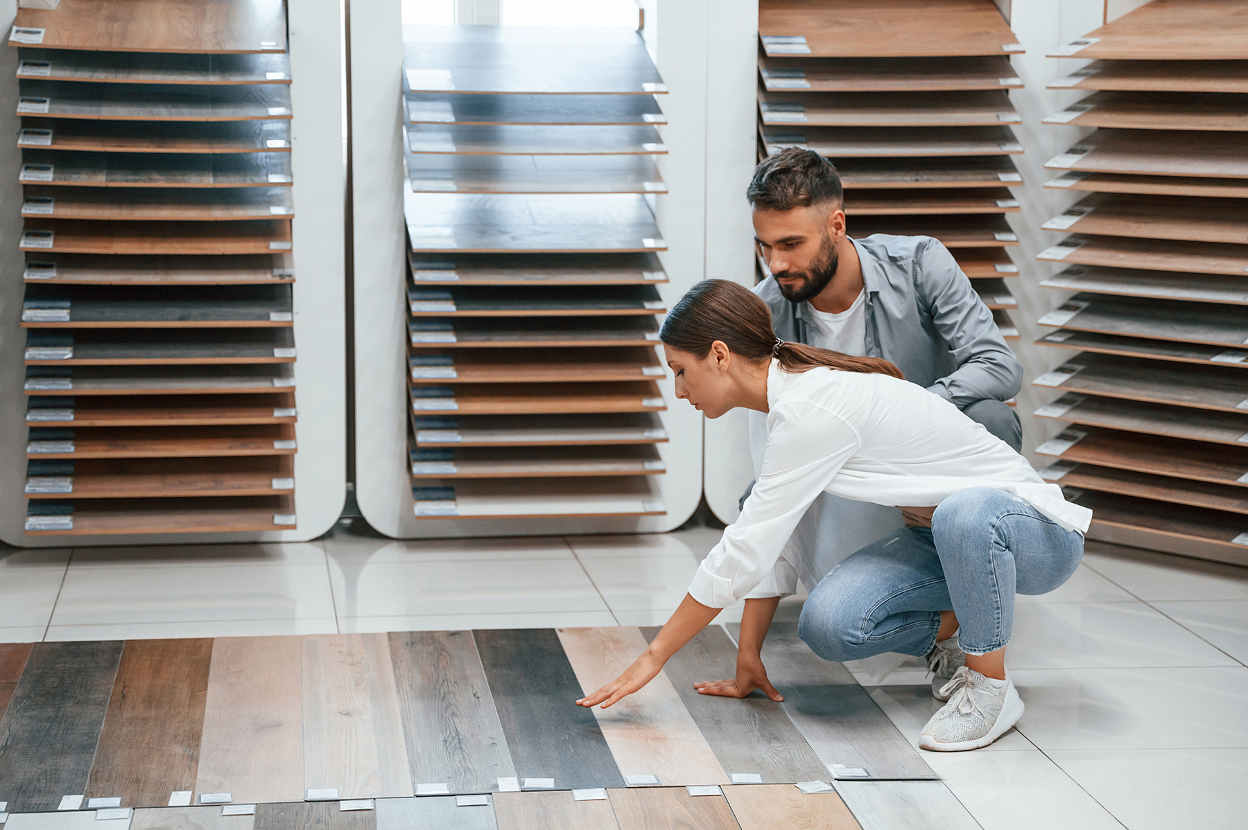 Sitting and choosing parquet. Woman and man is in the store of goods for the home
