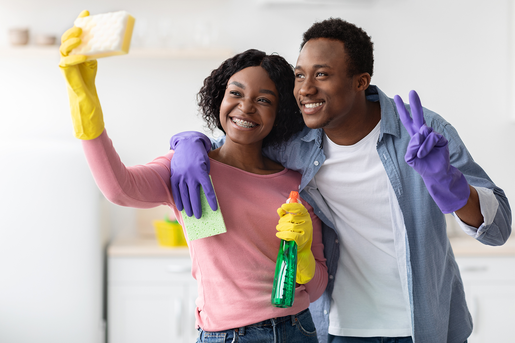 Cheerful african american lovers having fun while cleaning kitchen