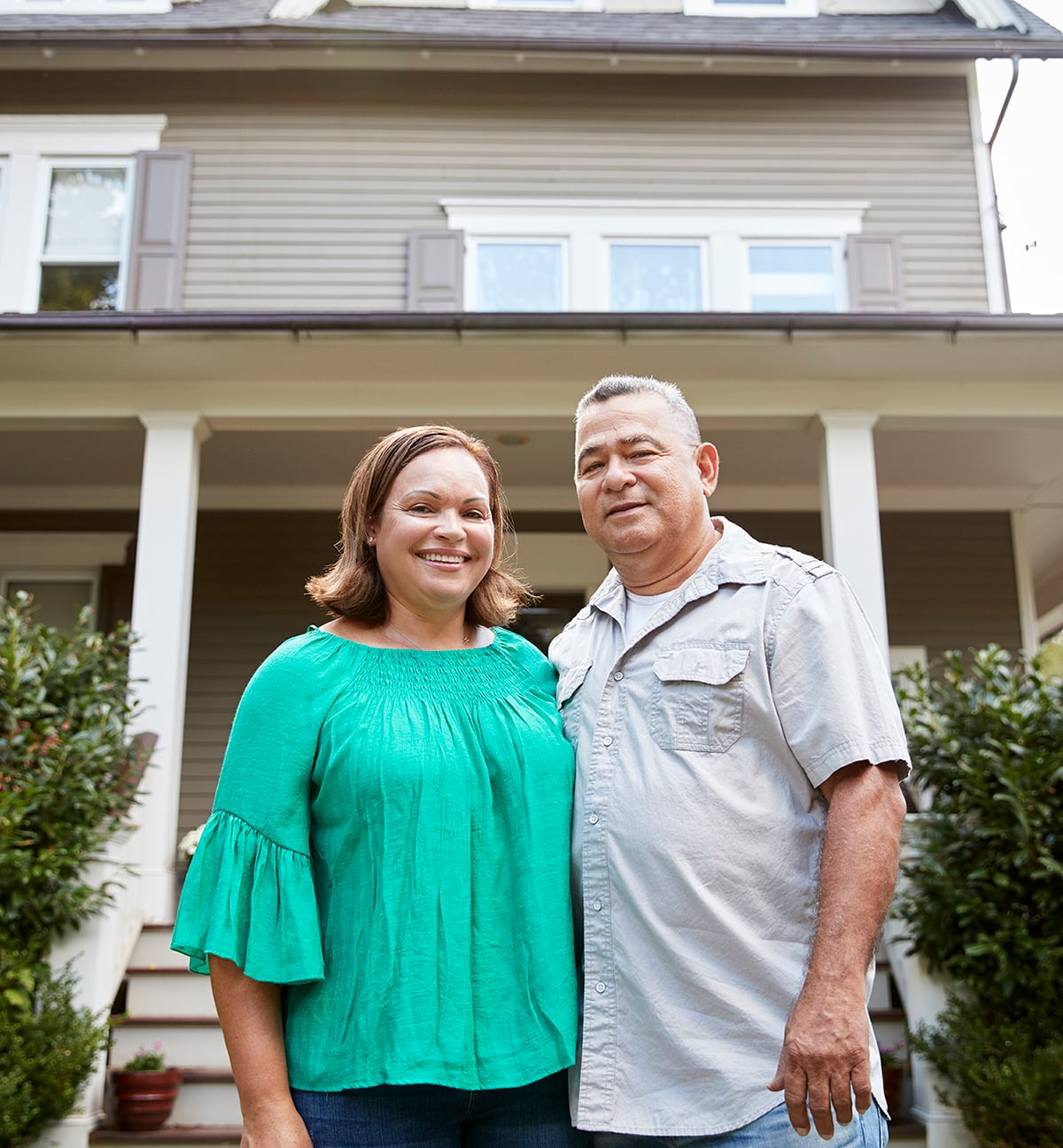 Portrait Of Smiling Senior Couple In Front Of Their Home