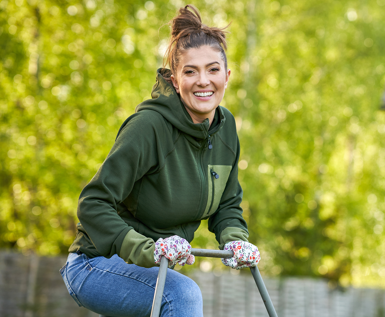 Woman working with lawn roller in the garden