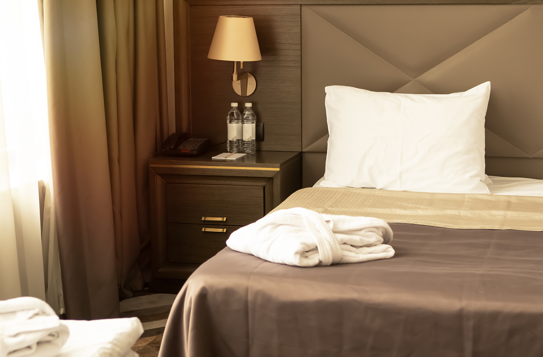 large-bed-in-a-hotel-room-with-bathrobes-2024-12-02-18-16-39-utc