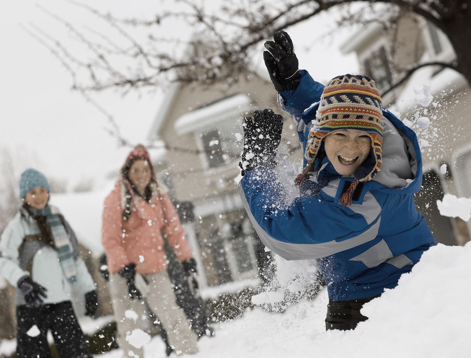 USA,Winter snow. Three children having a snowball fight.