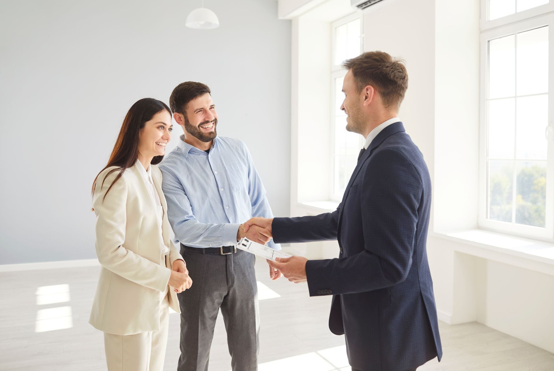 Family couple shakes hands with a real estate agent or realtor, sealing an agreement on a new home purchase. Handshake represents trust and the successful finalization of a property deal. (1)
