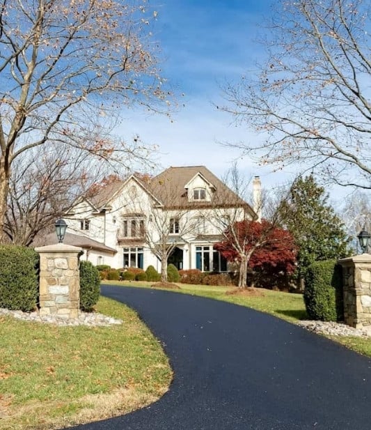 Asphalt driveway to large country house.