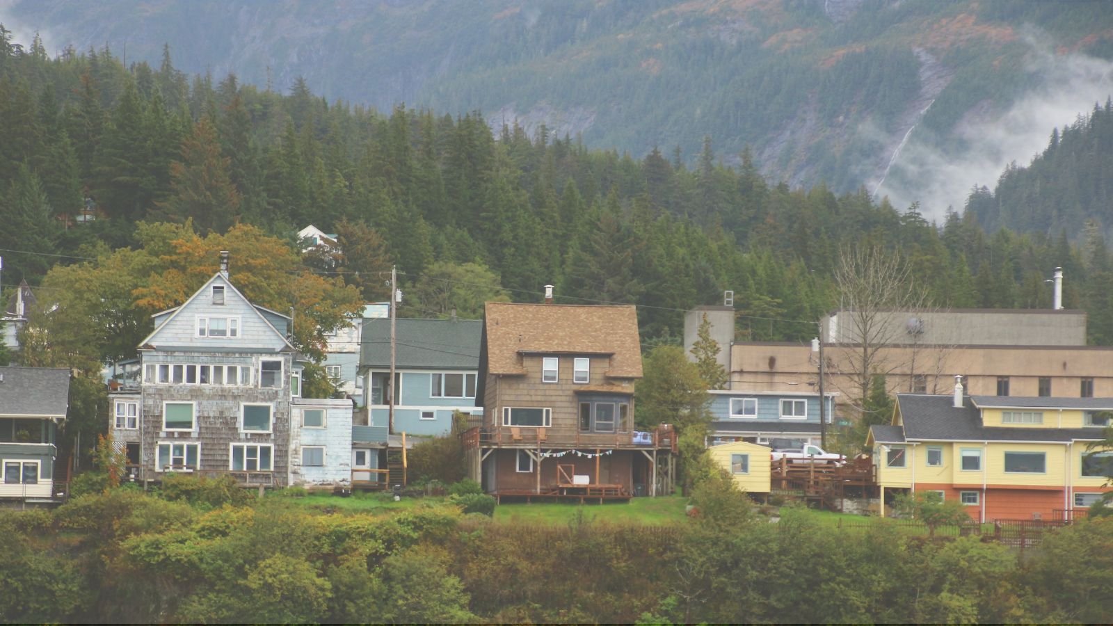 Homes in Alaska surrounded by mountains and forest