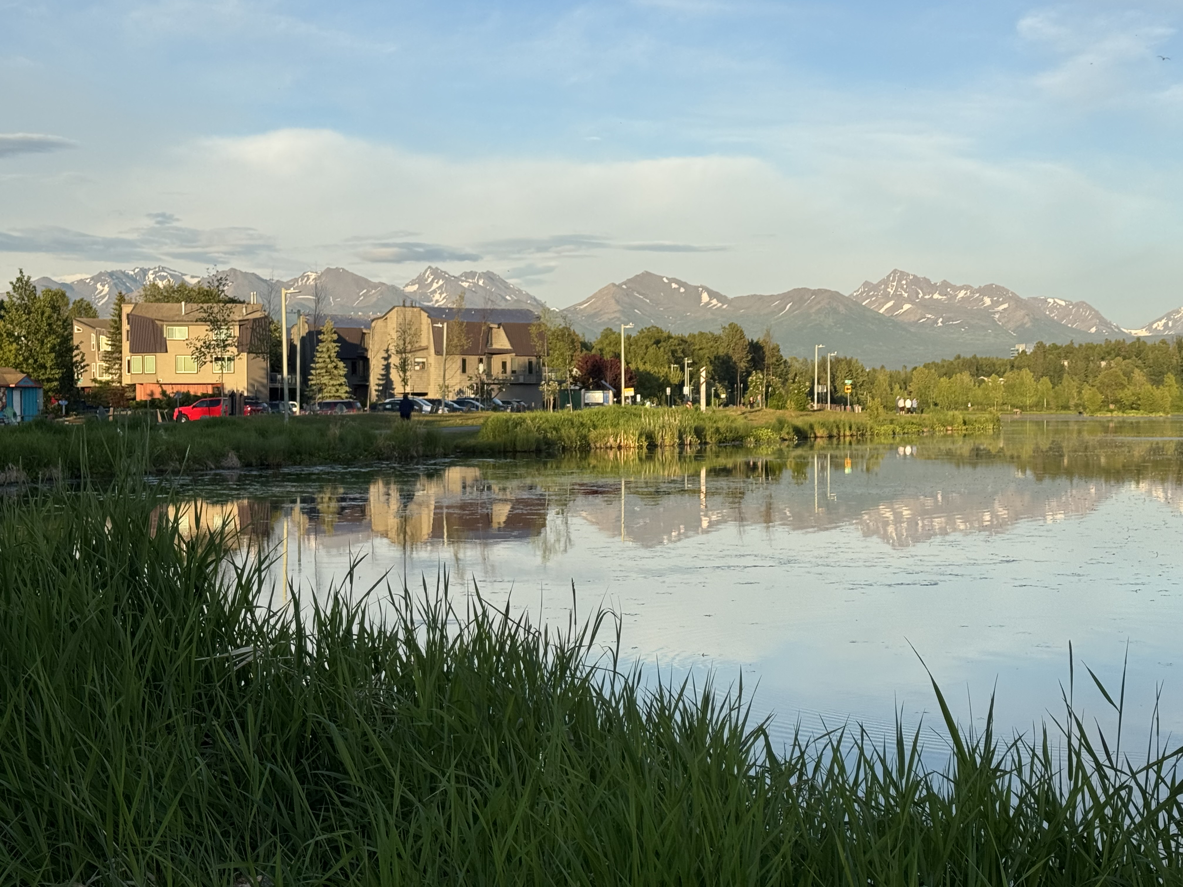 Anchorage home in late summer with snow appearing on the Chugach Mountains
