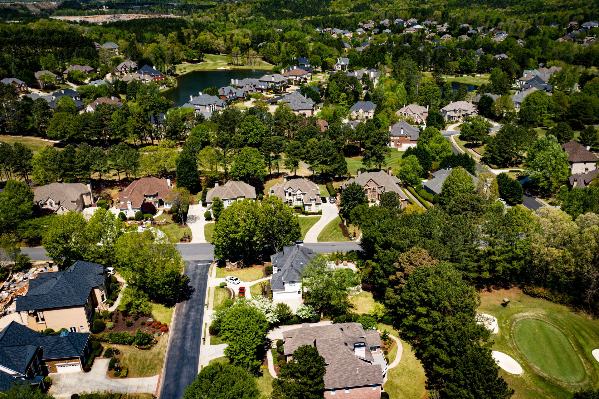Aerial panoramic view of house cluster in a sub division in Suburbs with golf course and lake in metro Atlanta in Georgia