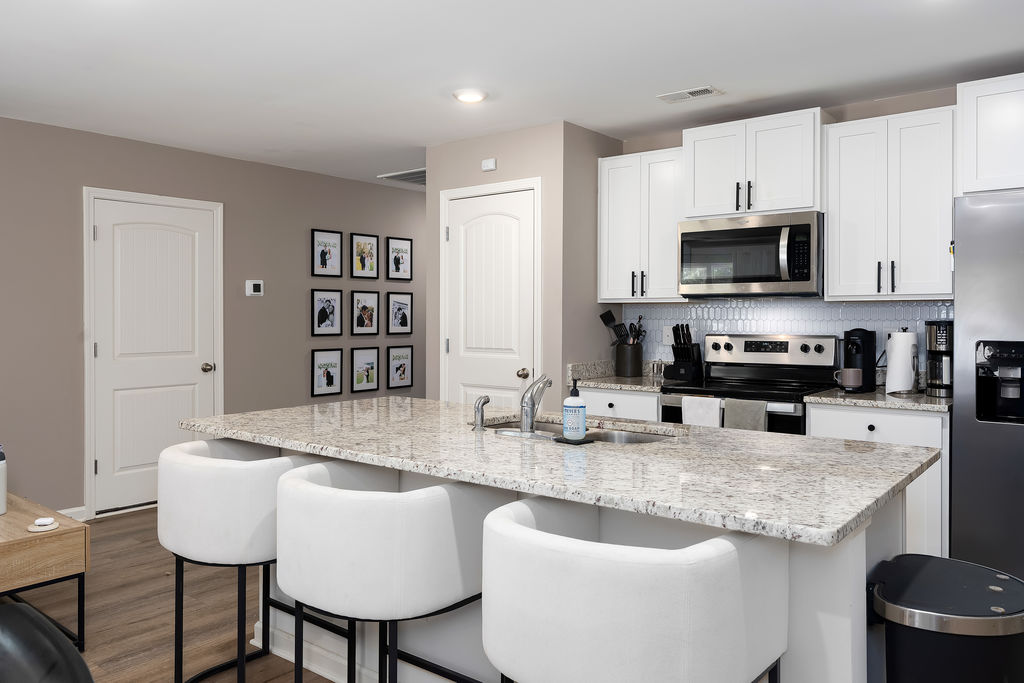 Granite island kitchen with white shaker cabinets and pantry door, Chelsea Acres