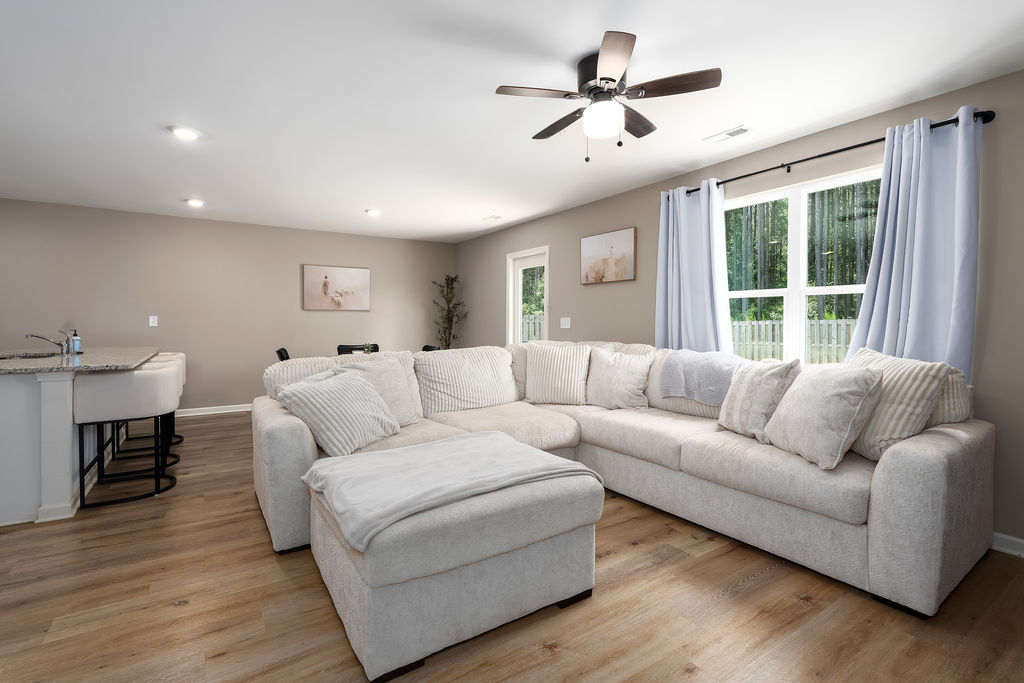 Living room with ceiling fan and backyard views in a Chelsea, Alabama home