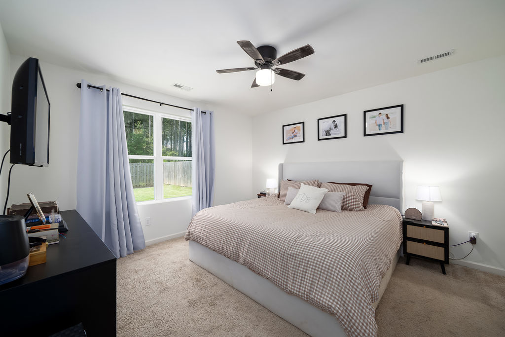 Primary bedroom with ceiling fan and carpet in a one-level Chelsea, AL home