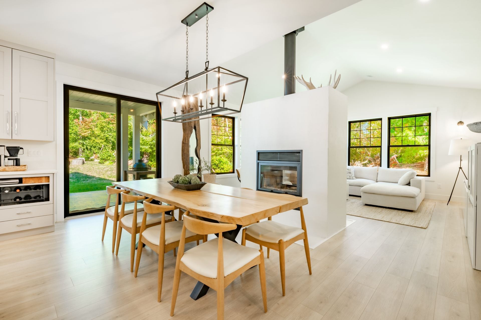 Modern farmhouse kitchen interior with light wood floors white granite marble counters large dining table with eight chairs