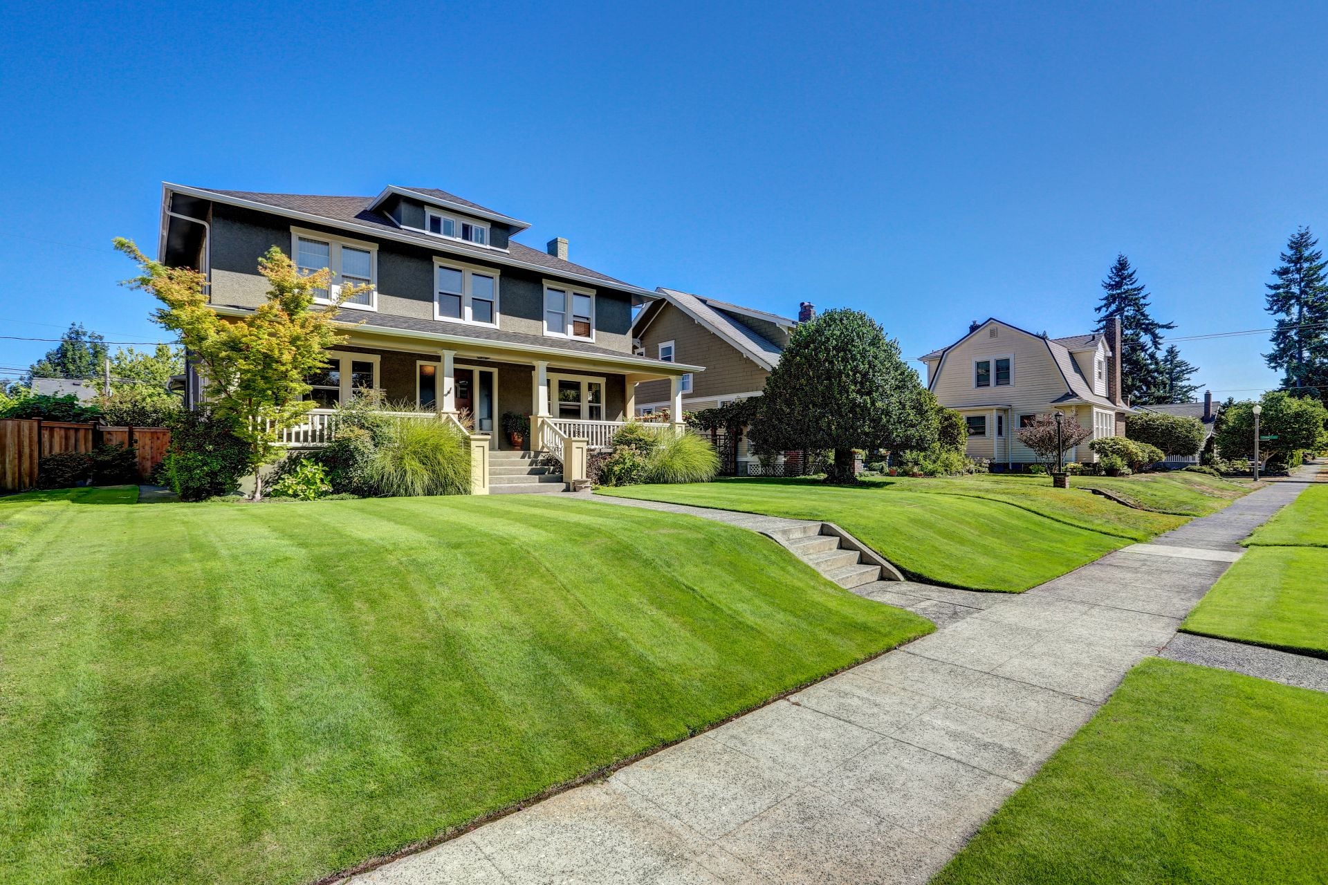 Nice curb appeal of American craftsman style house. Column porch view and freshly mowed garden lawn. Northwest, USA