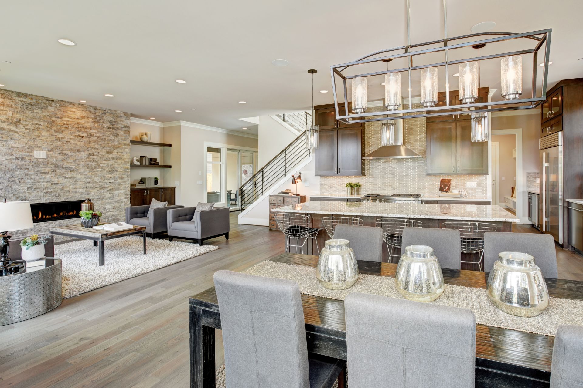 Open plan kitchen equipped with high-end appliances opens to the dining room and the great room with a floor to ceiling stone fireplace.