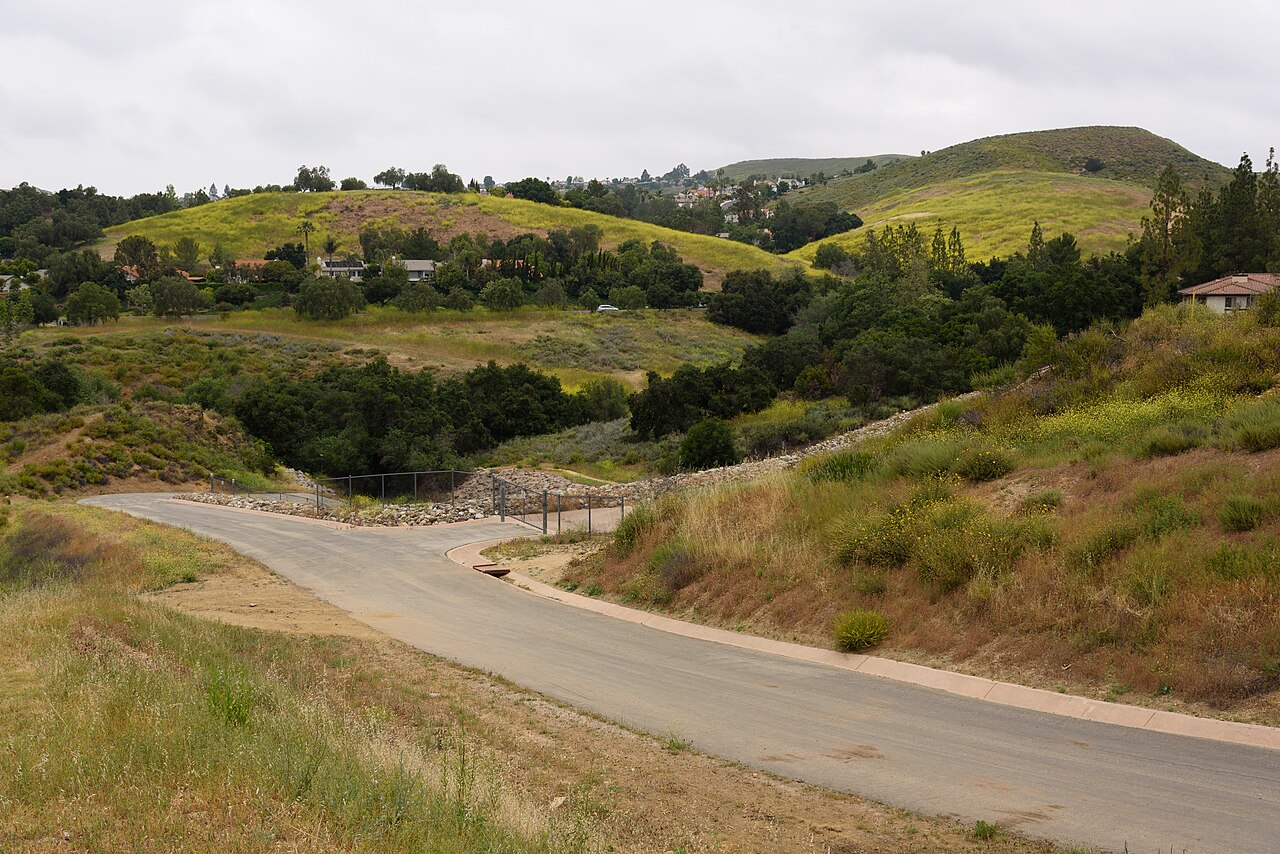 Rolling hills and pathway at Sapwi Trails Community Park where the disc golf course plays