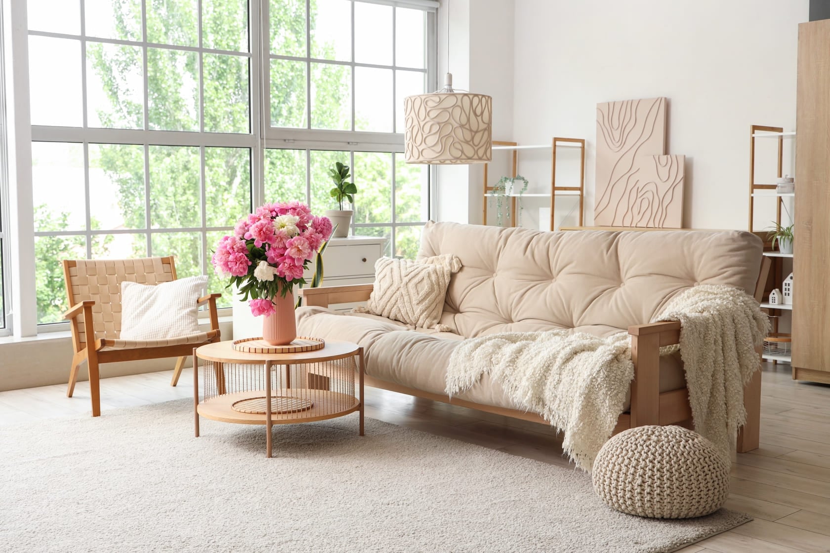 Armchair, sofa and coffee table with peonies in interior of living room (1)