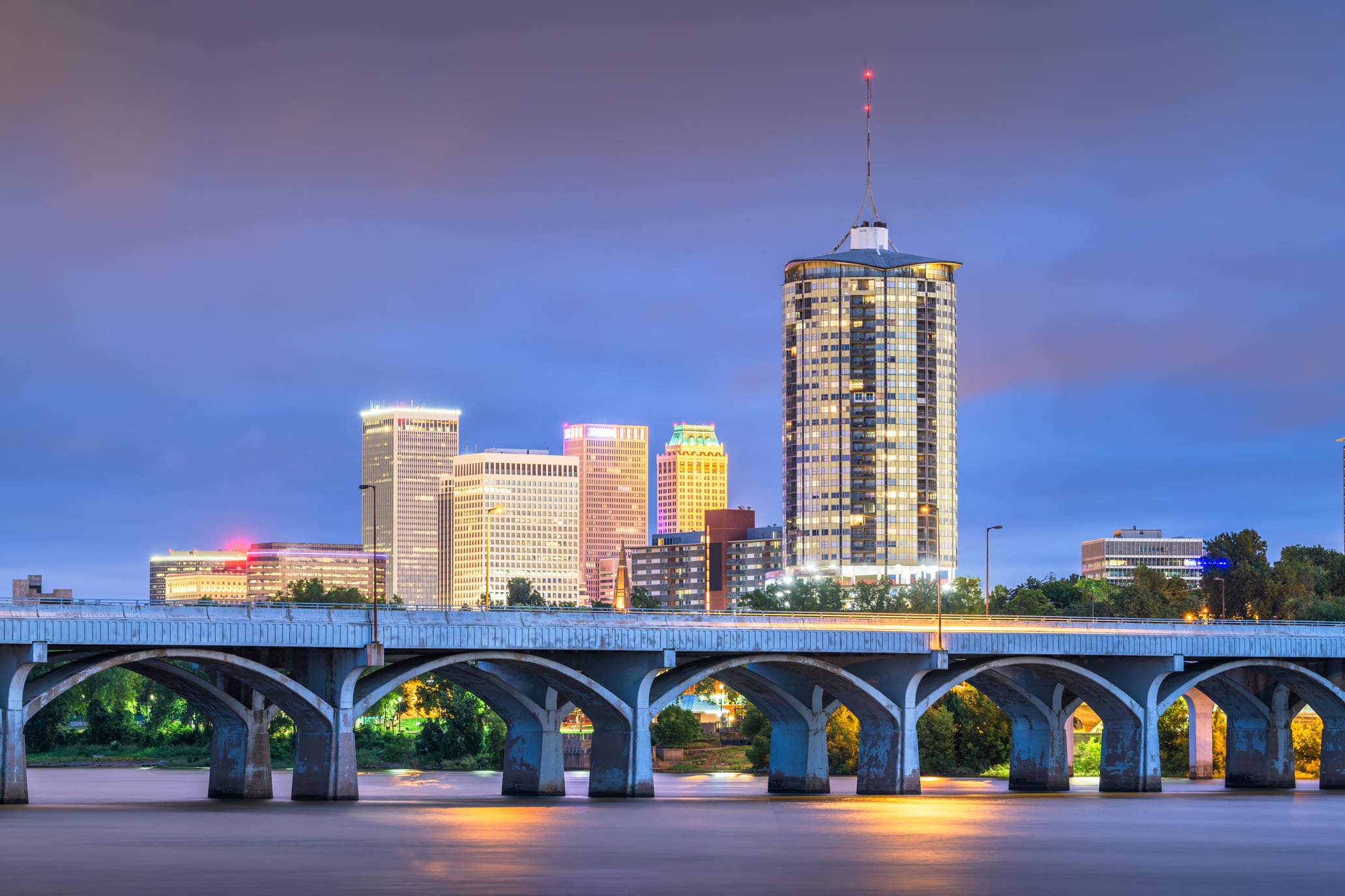 Tulsa, Oklahoma, USA downtown skyline on the Arkansas River at dusk.