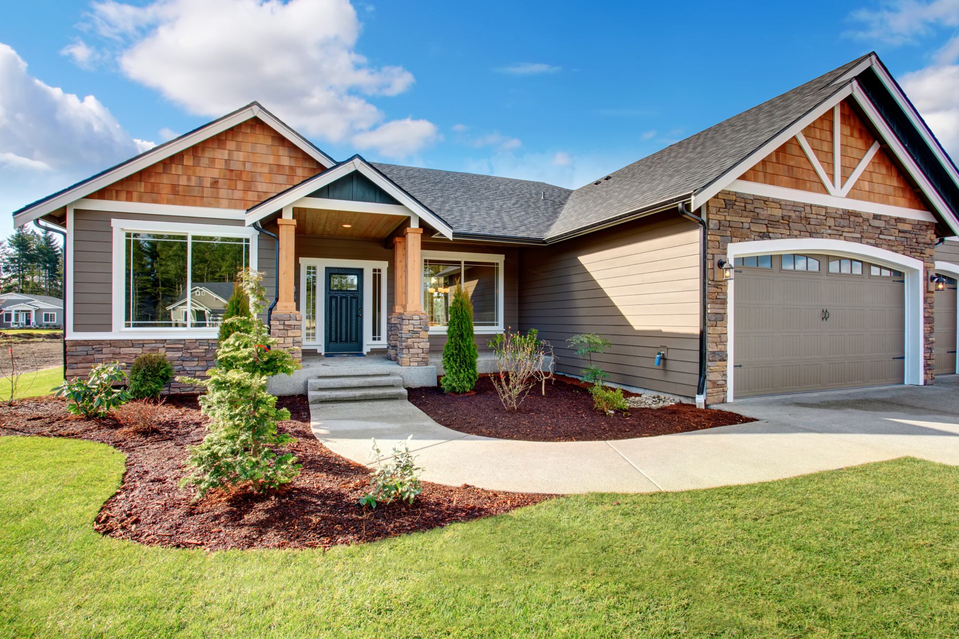 Large modern house with walkway and lots of grass.