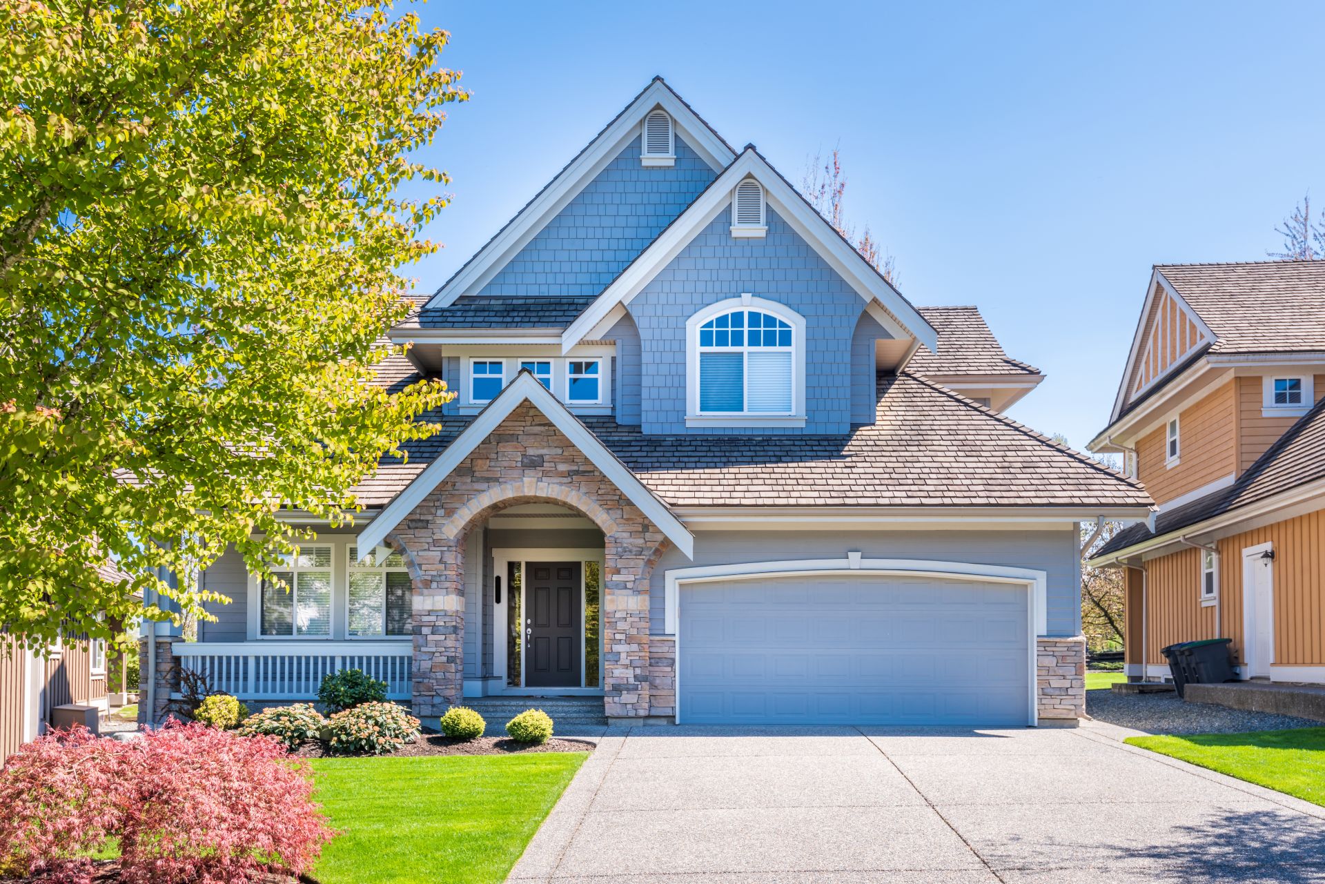 Beautiful exterior of newly built luxury home. Yard with green grass and walkway lead to front entrance.