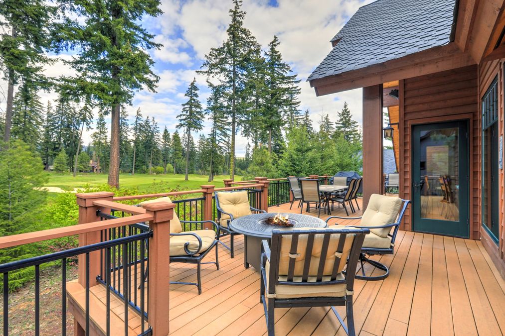 Beautiful large cabin home with large wooden deck and chairs with table overlooking golf course. (1)