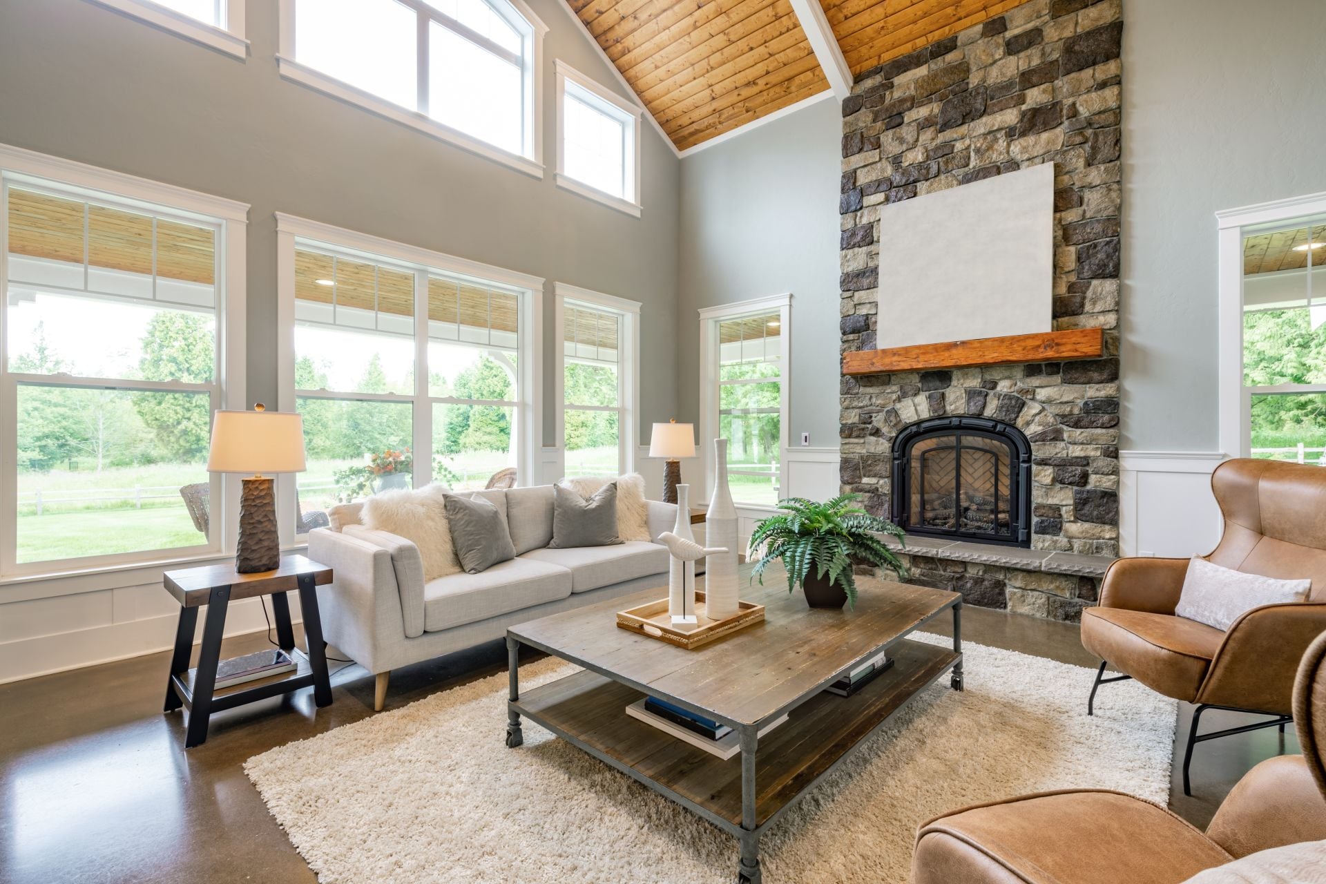 Living room interior with wooden beams hardwood flooring area rug furnishings sofa fireplace cabinets