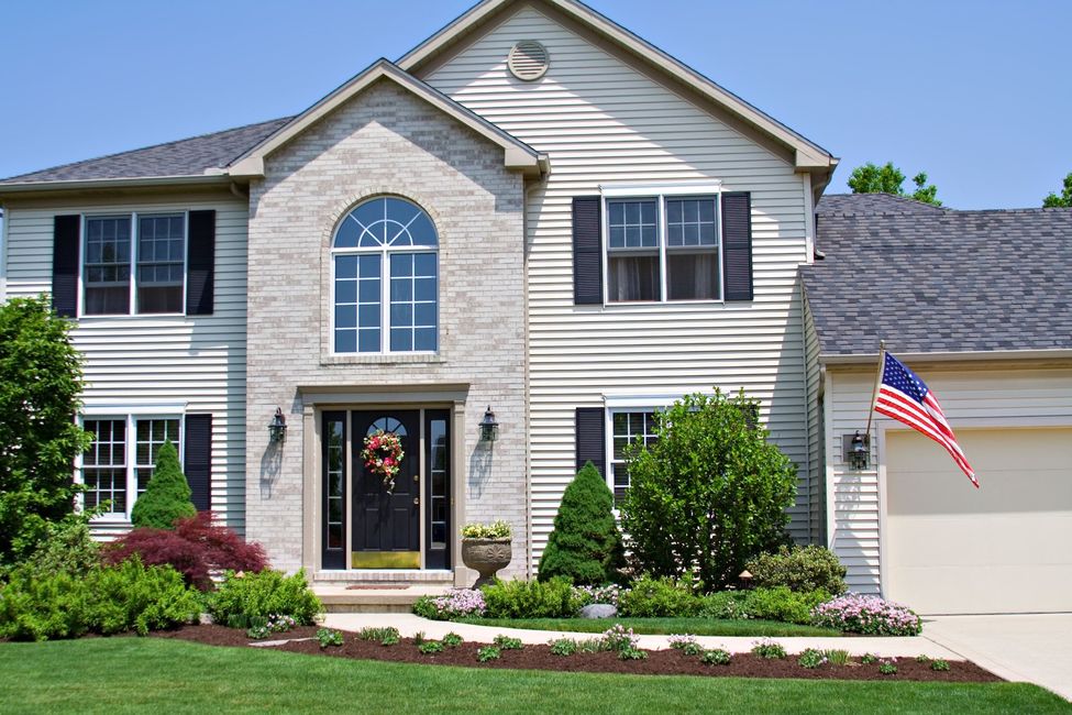 A beautiful neat suburban home in Ohio flying the American Flag.
