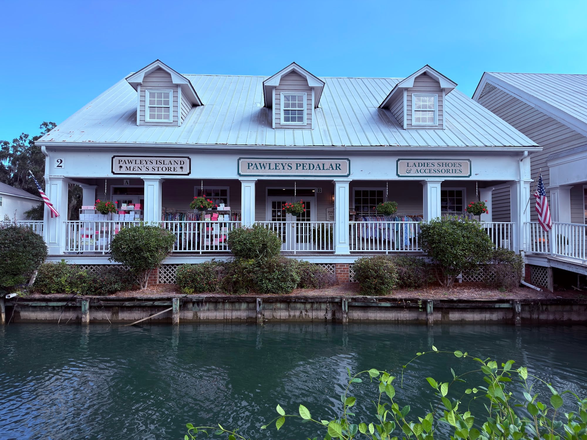 White porch storefront of Pawleys Island Men's Store at Oak Lea on Highway 17, overlooking the pond
