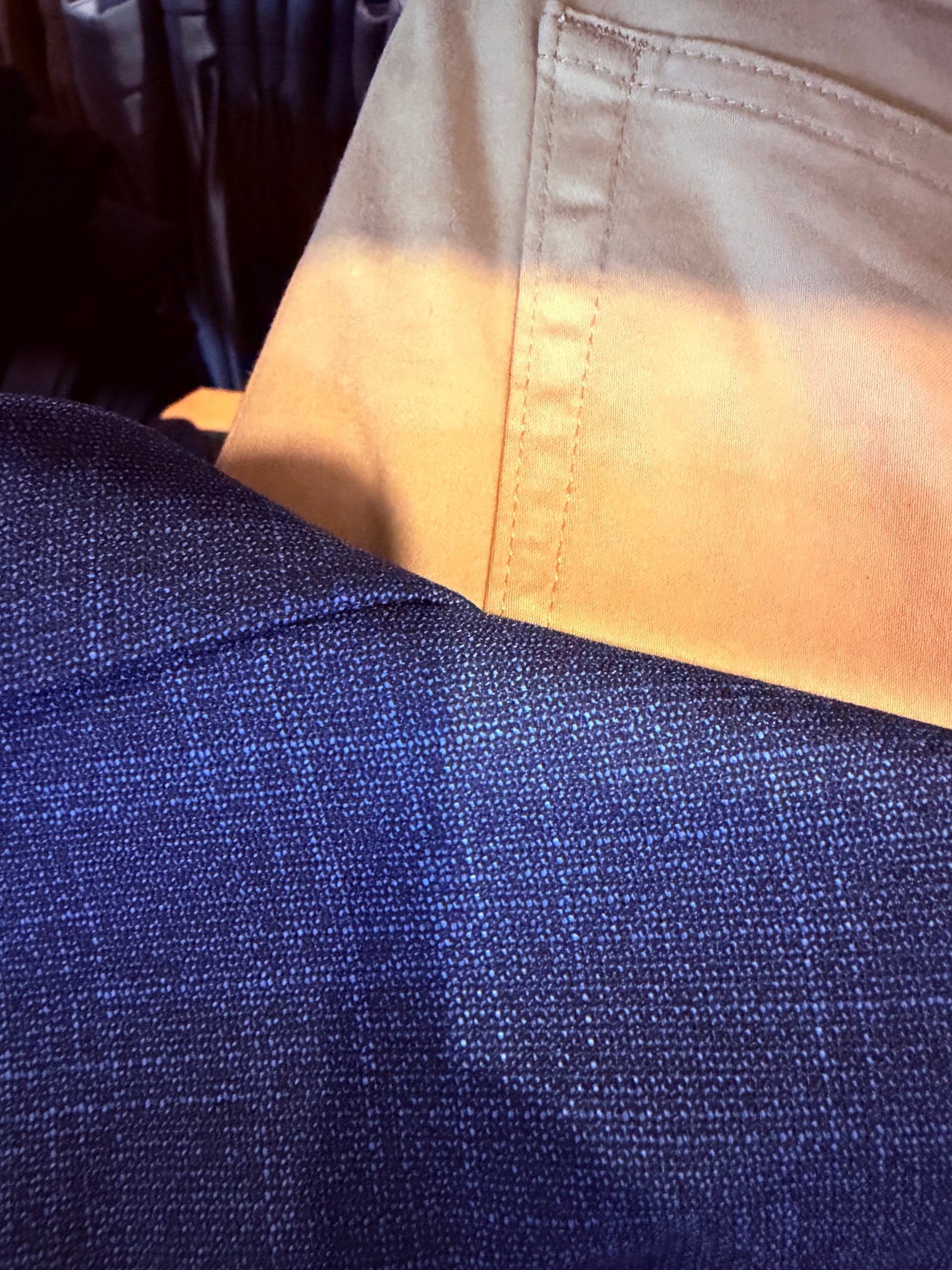 Close-up of navy blazer fabric texture against a cream dress shirt