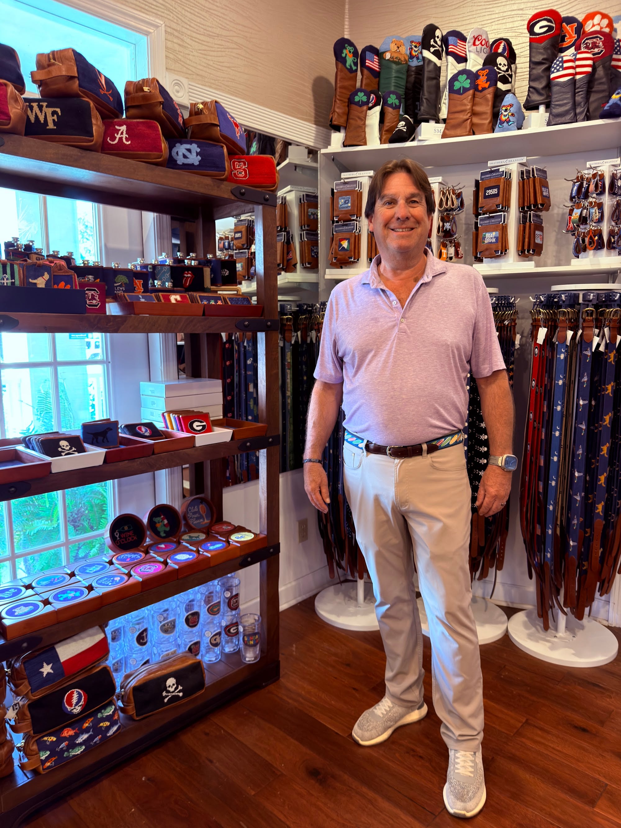 Rob of Pawleys Island Men's Store in front of the Smathers & Branson needlepoint belt and koozie wall