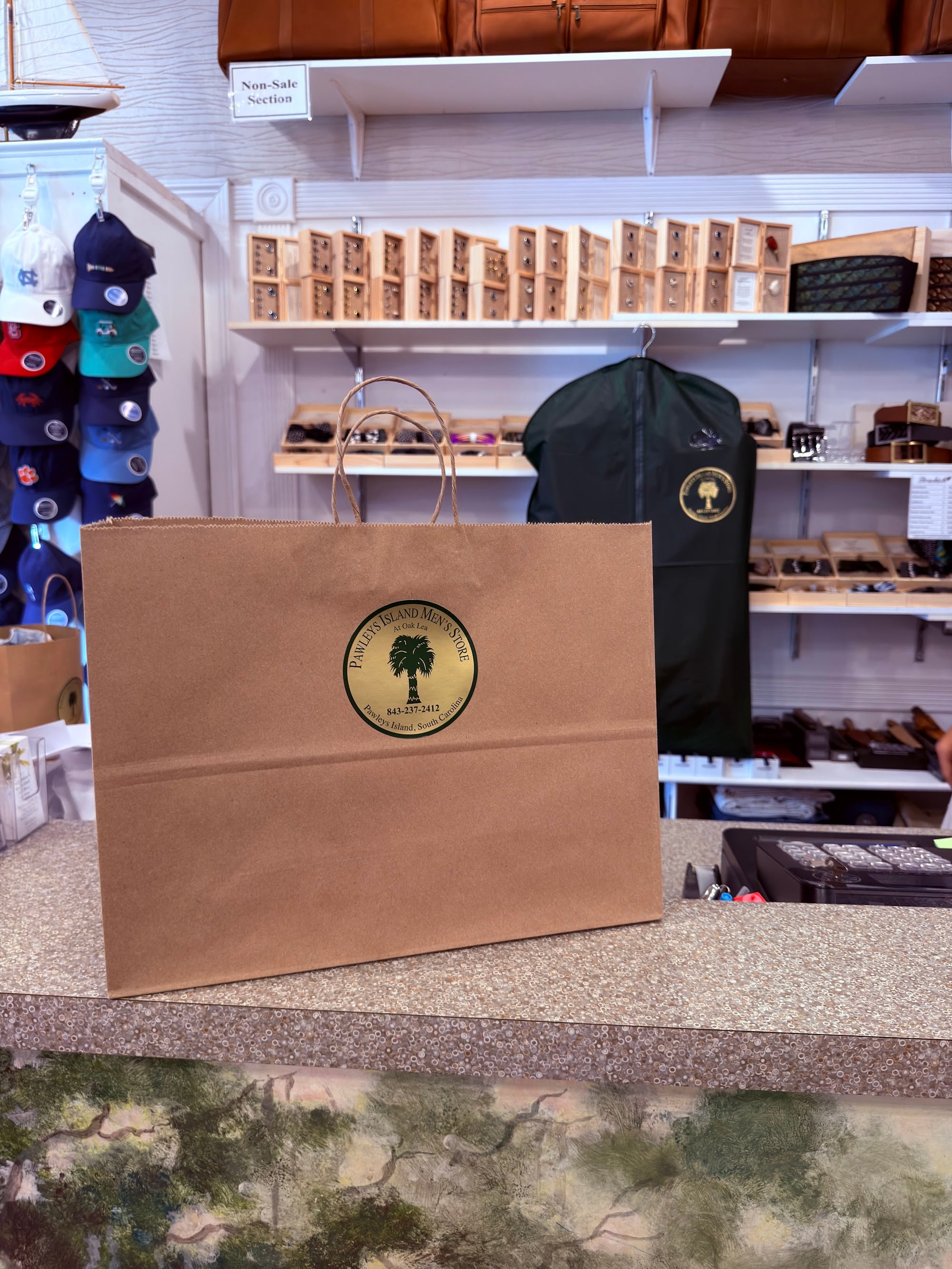 Pawleys Island Men's Store shopping bag with the palmetto logo on the counter