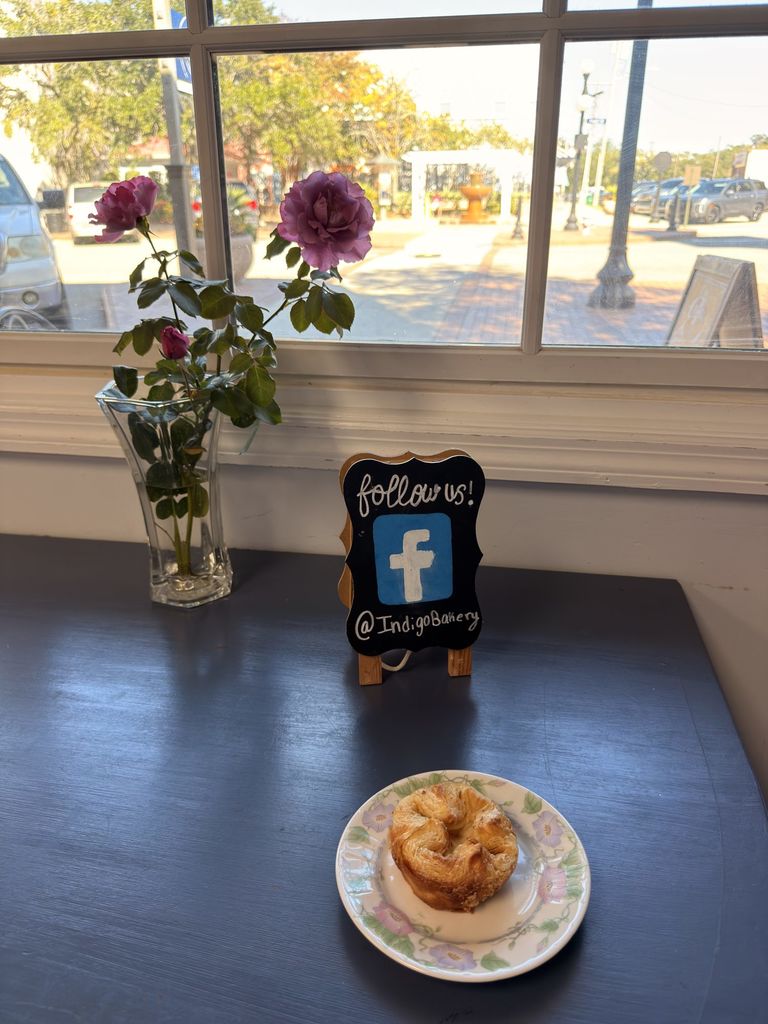 Kouign-amann by the front window with a follow us sign at Indigo Bakery