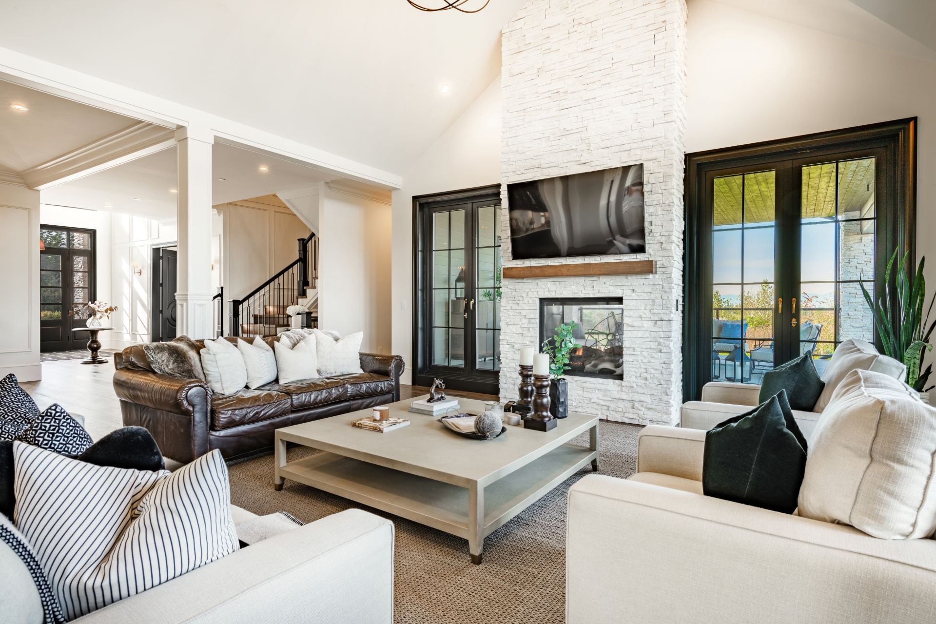 Living room interior beamed ceilings fireplace overstuffed leather sofa designer decor view to kitchen and dining