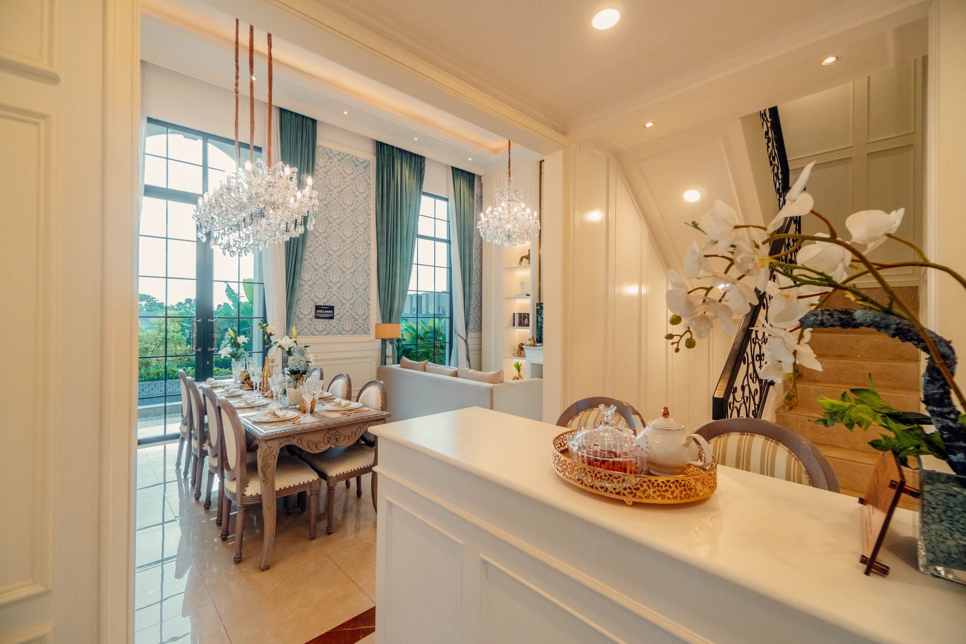 dining room with luxurious chandeliers with a warm feel, luxurious interior dining table and large, luxurious glass windows