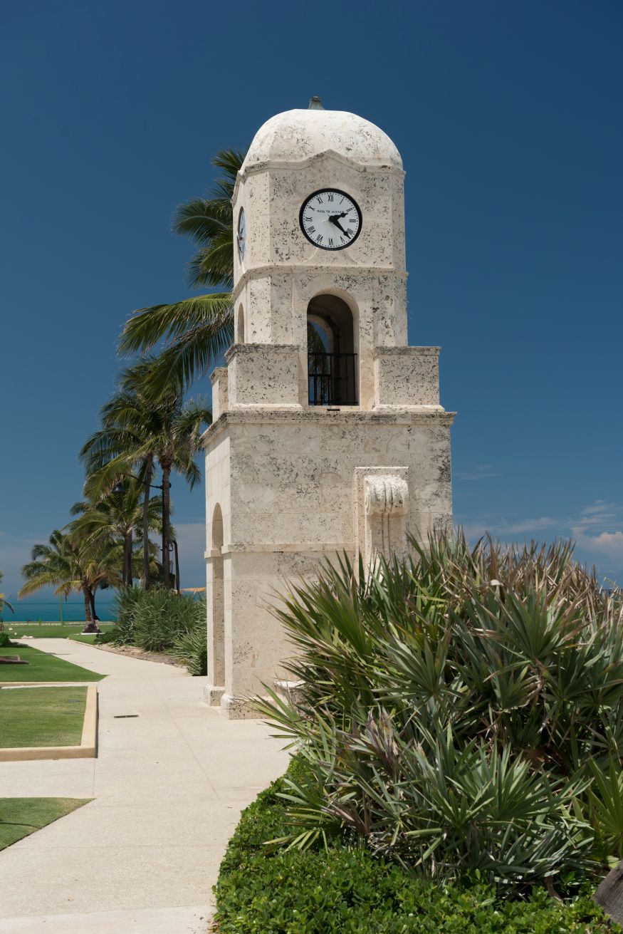 Sunny beach qith orange and green umbrwlaa in Palm Beach, FL