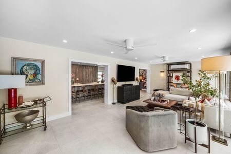 View from living room into gourmet kitchen and kitchen stools at the island at 3481 NE 18th Avenue Oakland Park FL