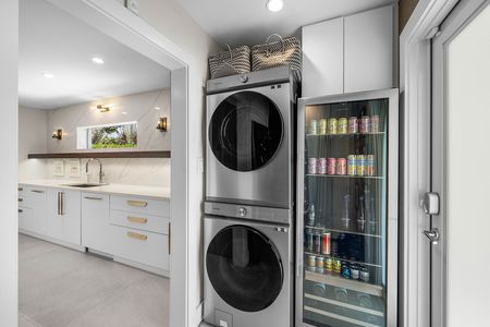 Samsung full sized stackable front load washer and dryer and glass fronted beverage refrigerator at 3481 NE 18th Avenue Oakland Park FL