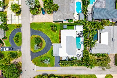 Aerial view of house and swimming pool and circular driveway with tropical landscaping at 3481 NE 18th Avenue Oakland Park FL