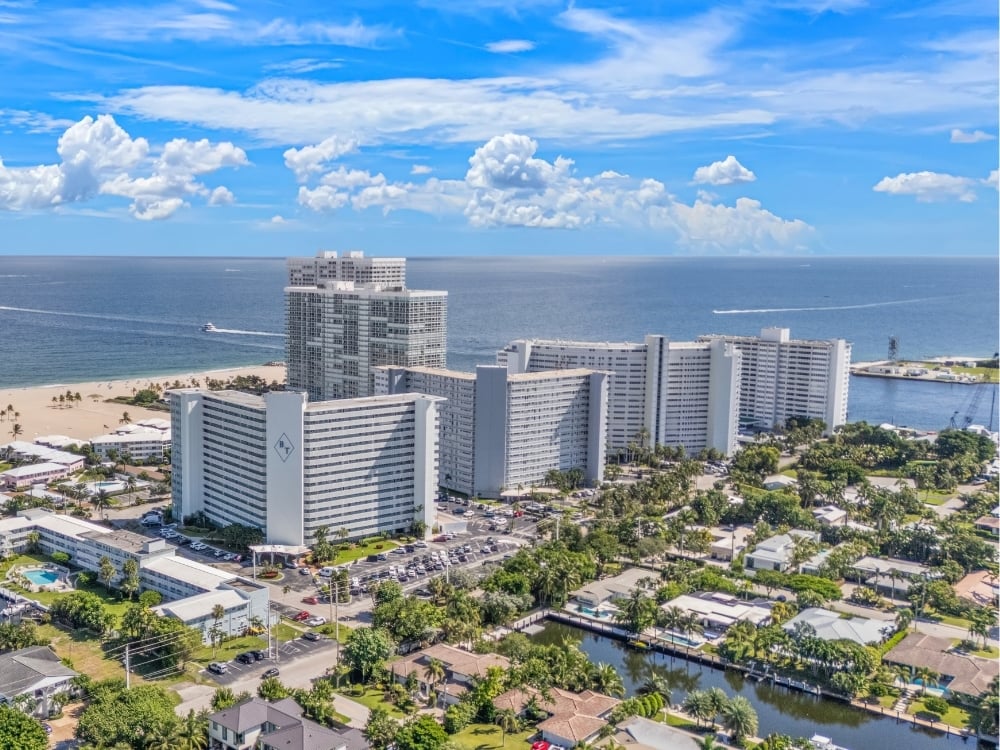 Aerial view of oceanfront condo towers by the beach and a canal in Fort Lauderdale, South Florida condo loan rules