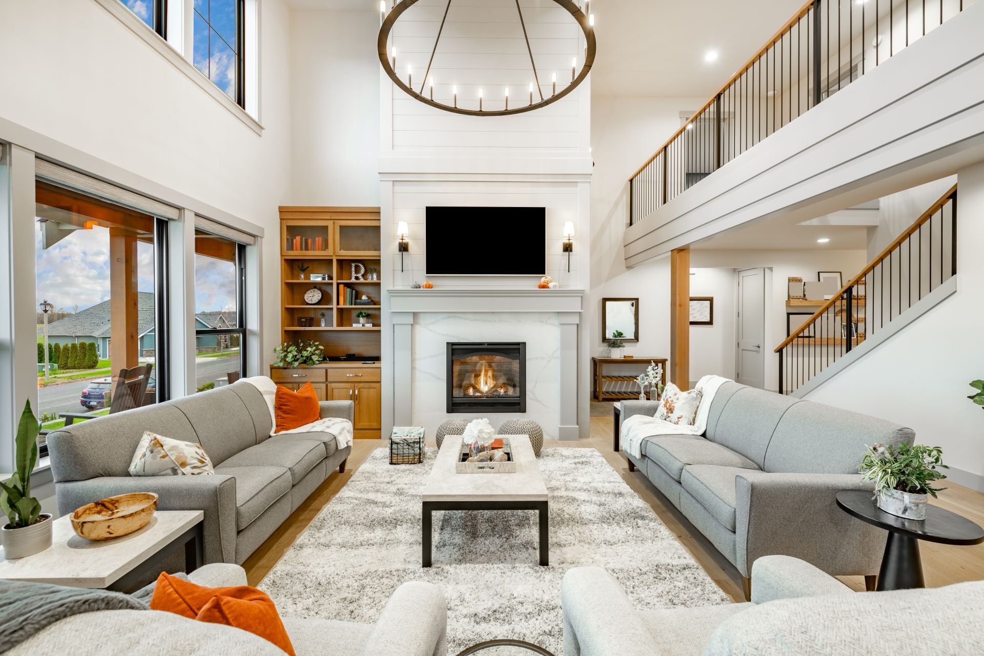 Modern farmhouse interior living room with hardwood floors built in shelving book case gas fireplace mantel