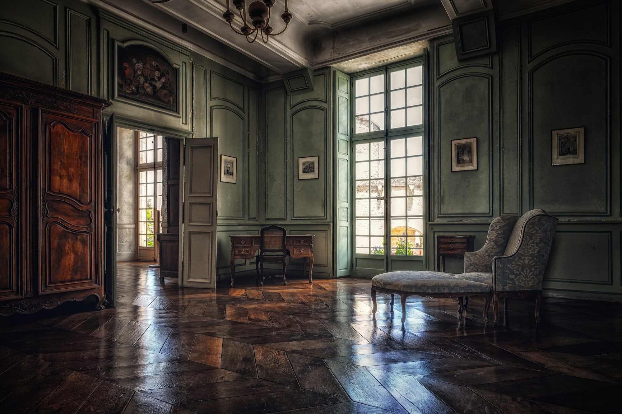 Paneled salon with antique furniture and herringbone floors