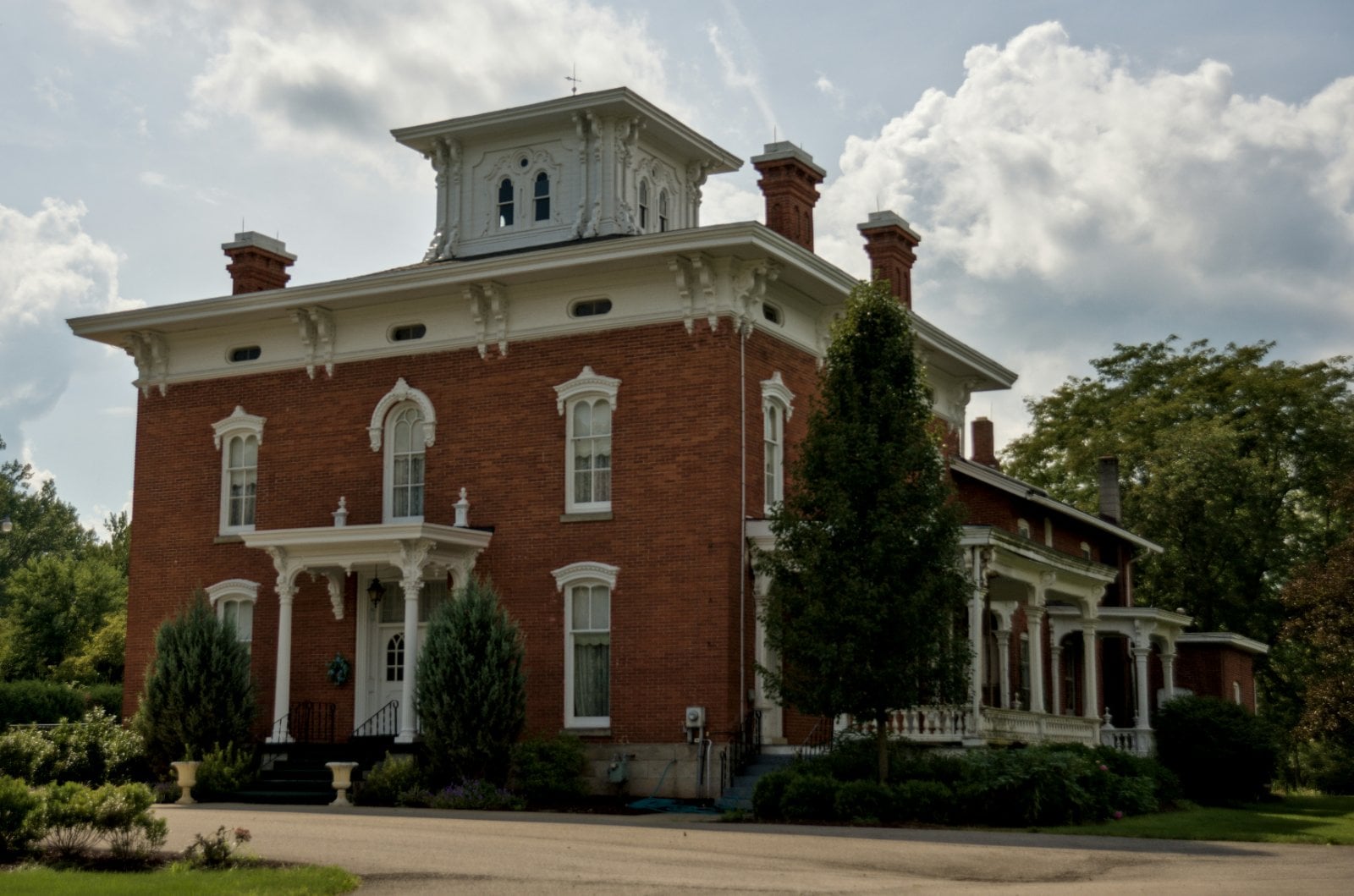 Red brick Italianate house with bracketed eaves and cupola